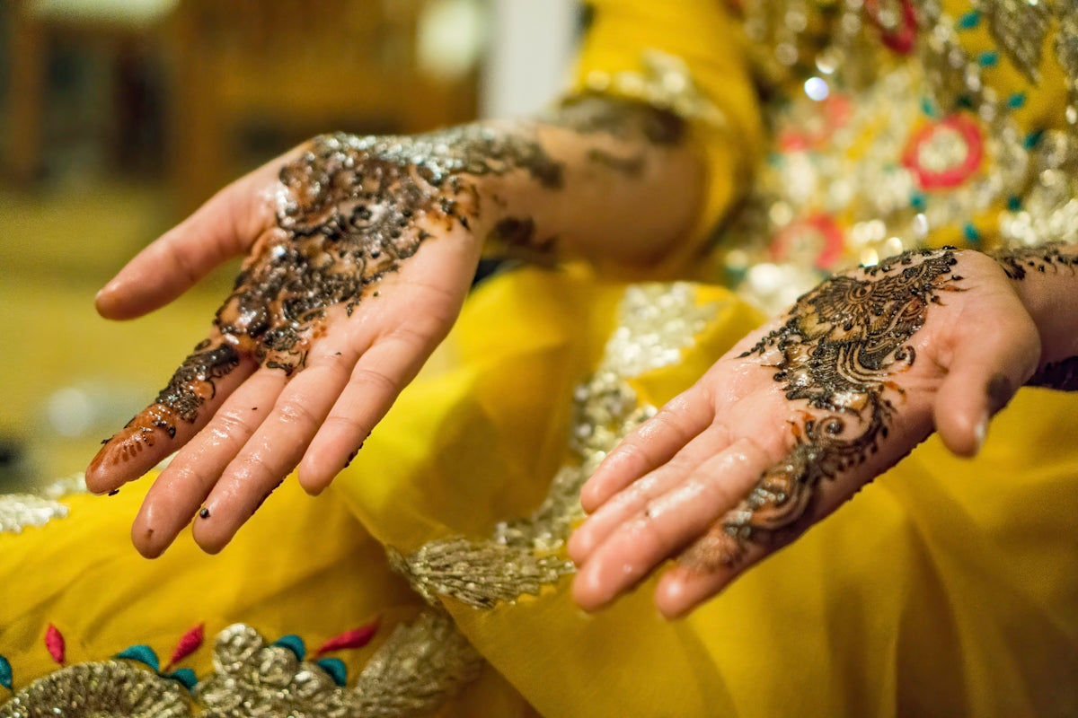 person's hands with mehndi tattoos
