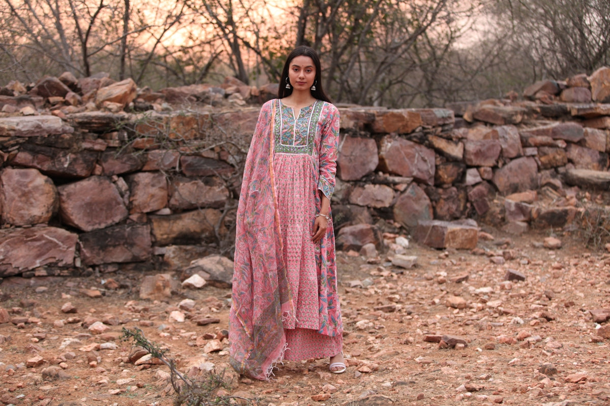 a woman standing in front of a stone wall