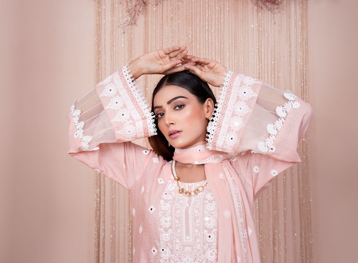 a woman in a pink outfit is holding her hands on her head