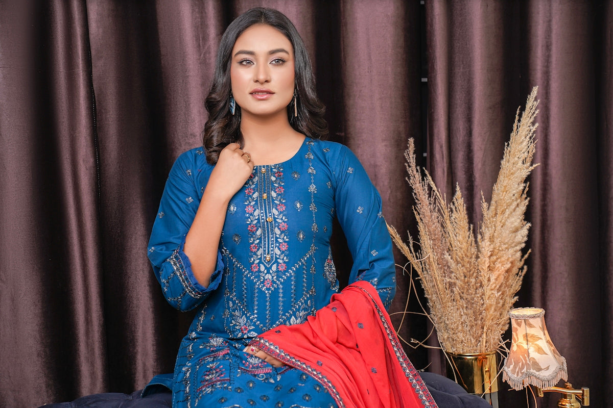 a woman sitting on a bed in a blue dress