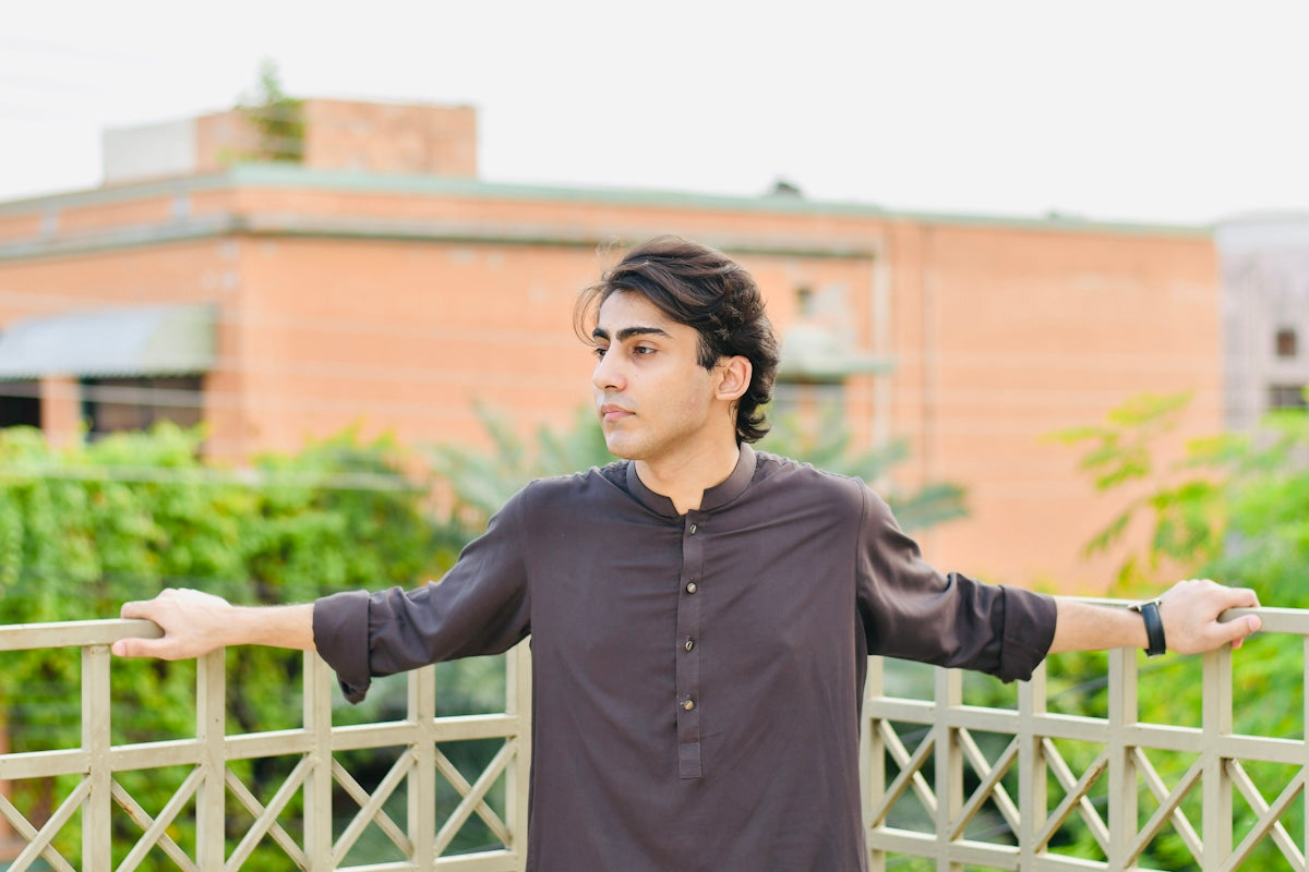 a man standing on a bridge with his arms outstretched
