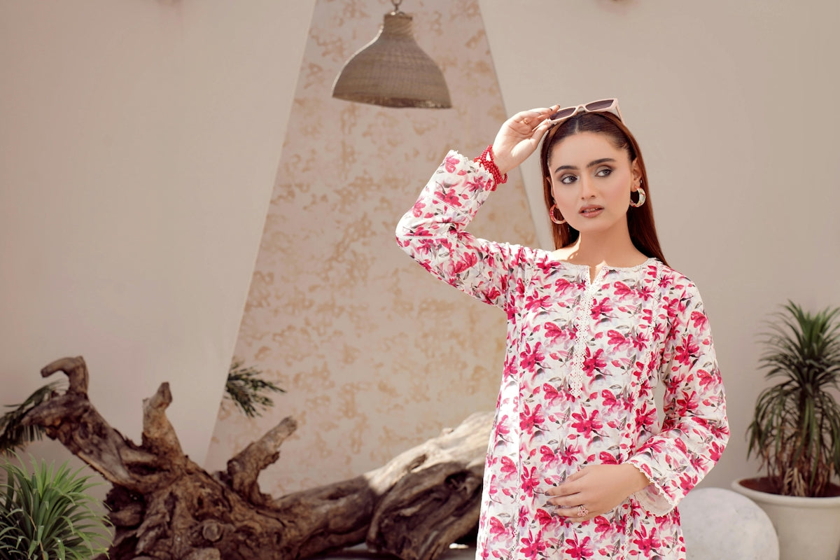 A young woman in a floral print dress poses indoors.