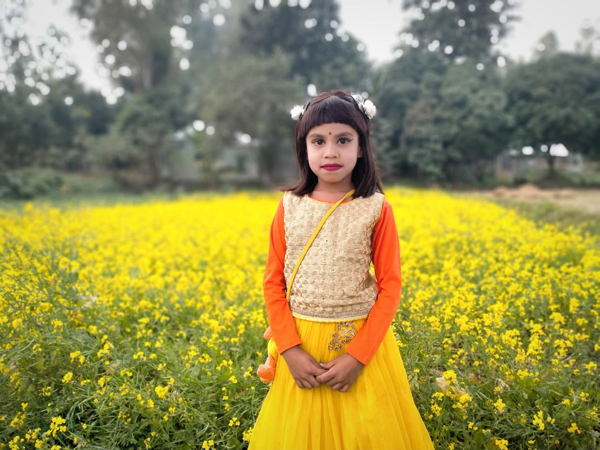a little girl standing in a field of yellow flowers
