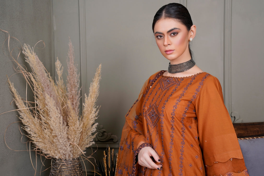 a woman standing next to a tall plant