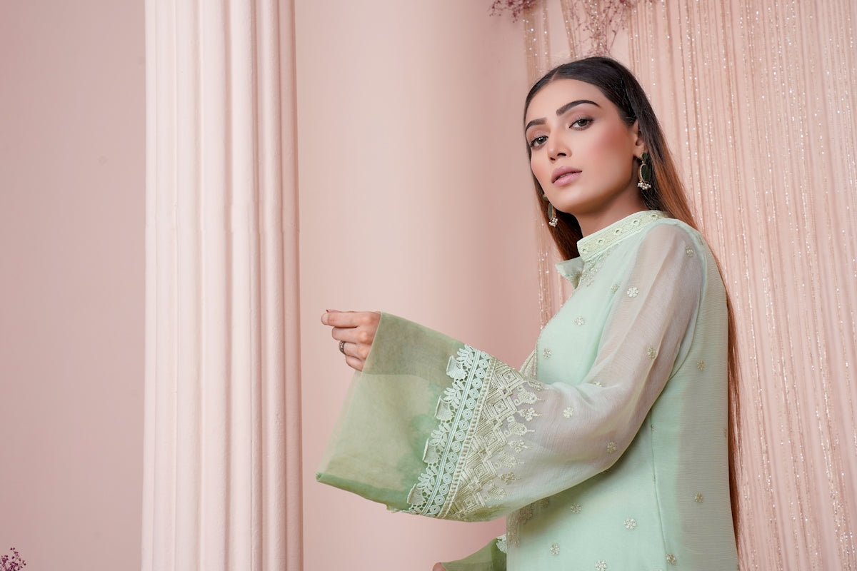 a woman in a green outfit holding a piece of cloth