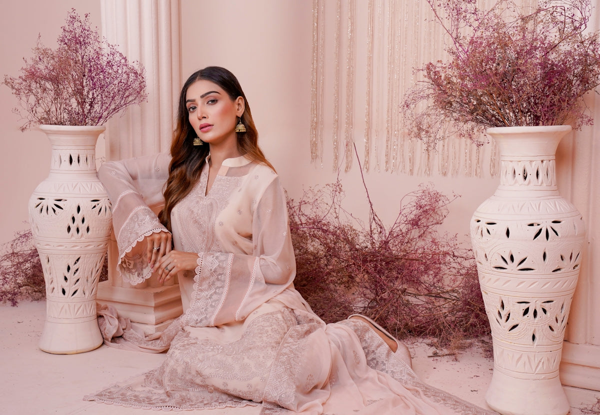 a woman sitting on a chair next to two vases