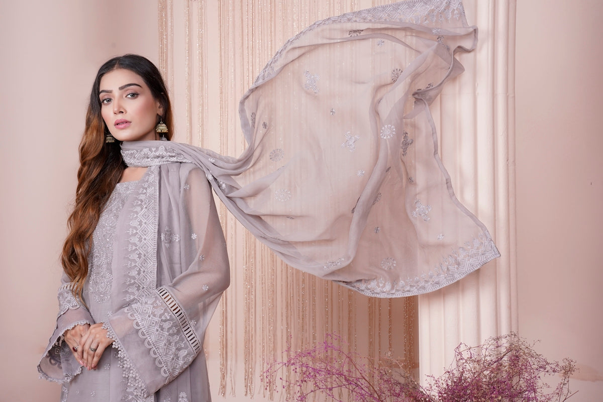 a woman standing in front of a sheer curtain