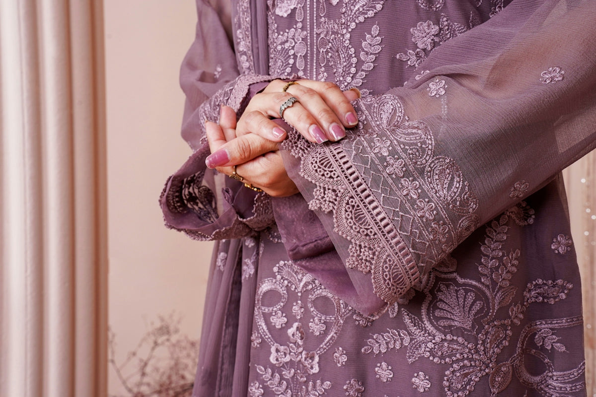 a woman in a purple dress holding her hands together