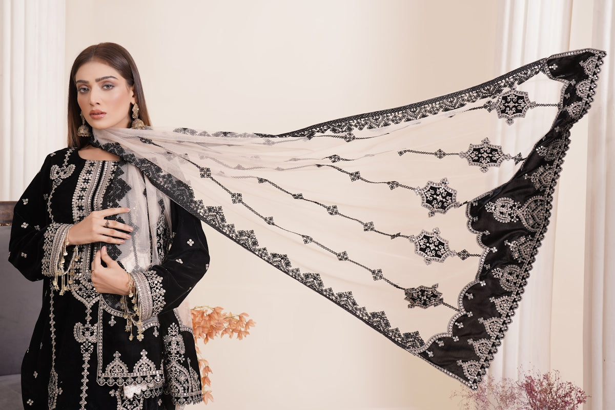 a woman in a black and white outfit holding a black and white shawl