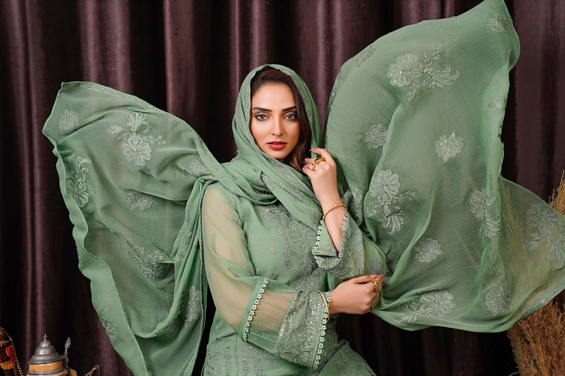 a woman in a green dress posing for a picture