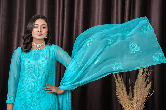 a woman in a blue dress holding a blue shawl