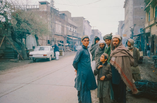A group of people standing on the side of a road
