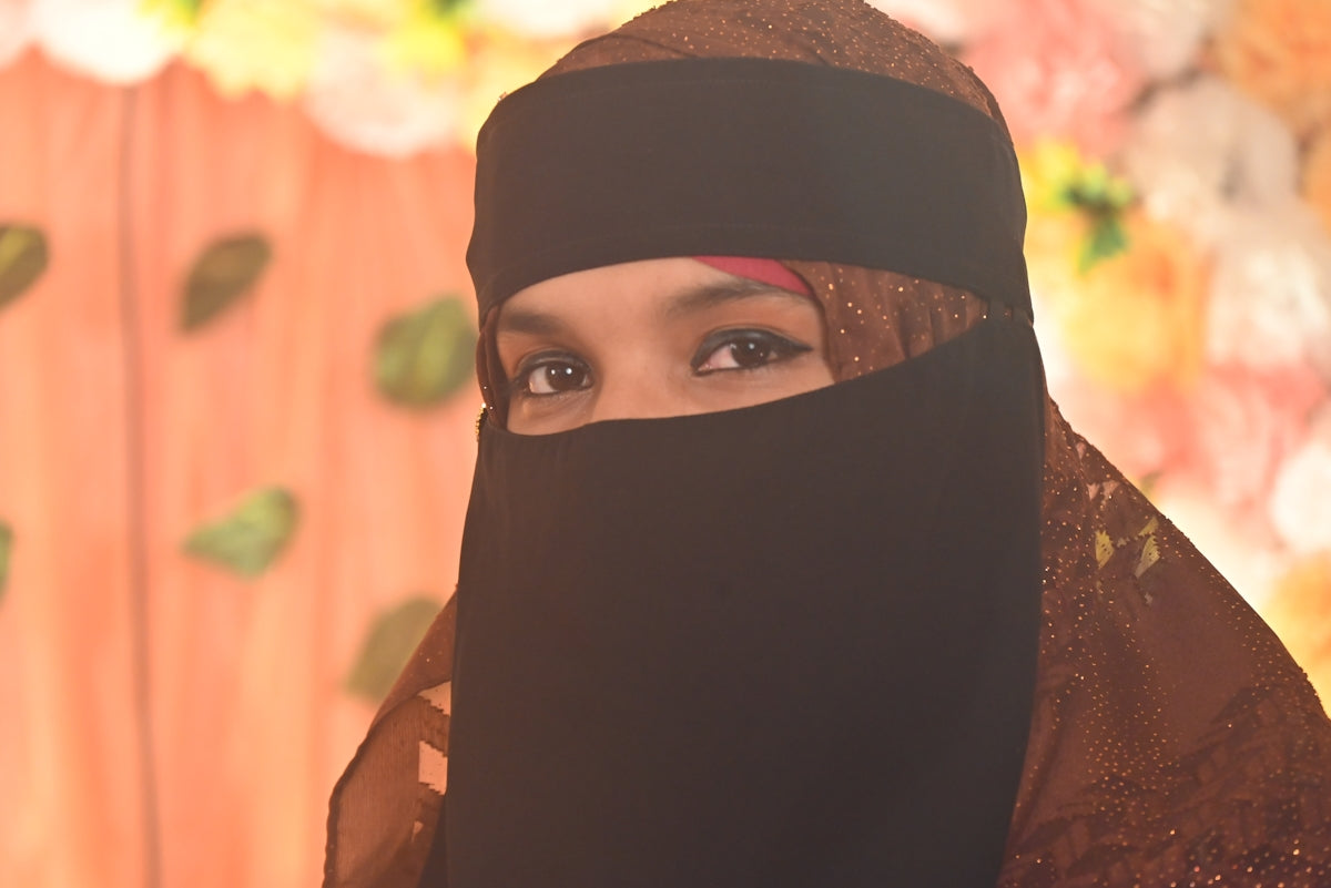 A woman is wearing a black niqab.