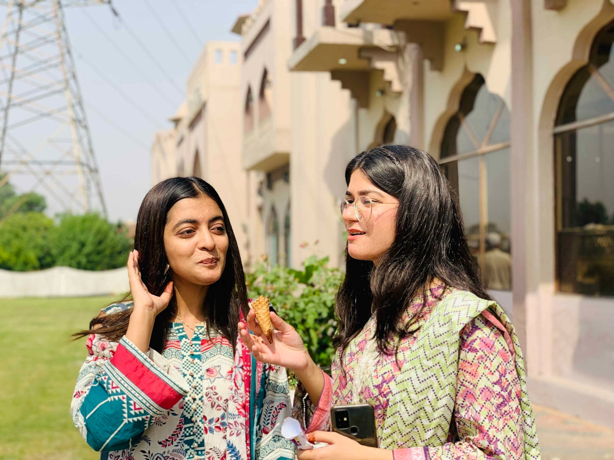 Two young women standing outdoors near a building.