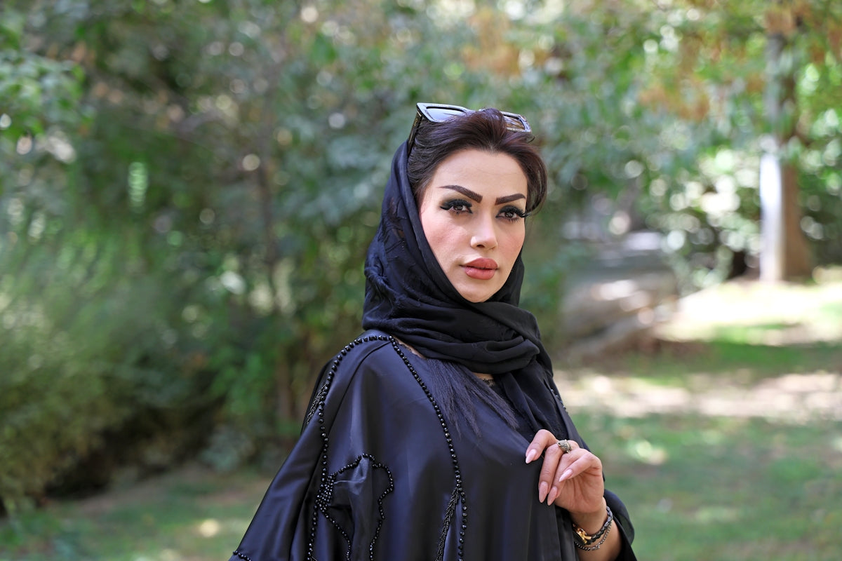 A woman in a black hijab and dress outdoors