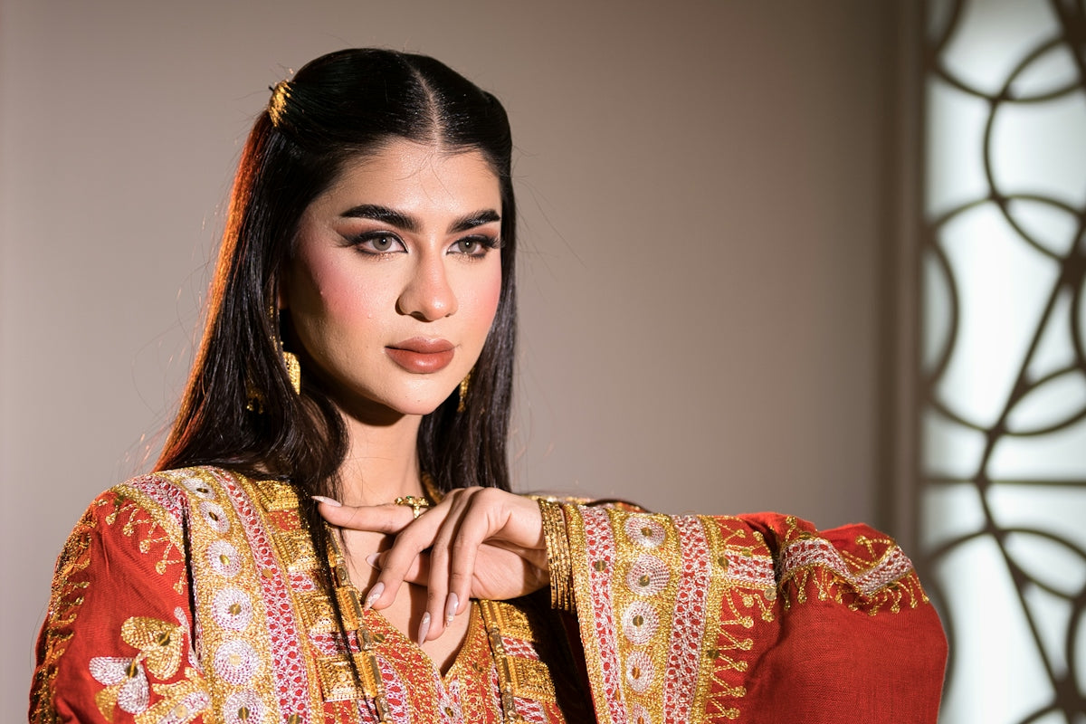 A woman in ornate traditional clothing poses gracefully
