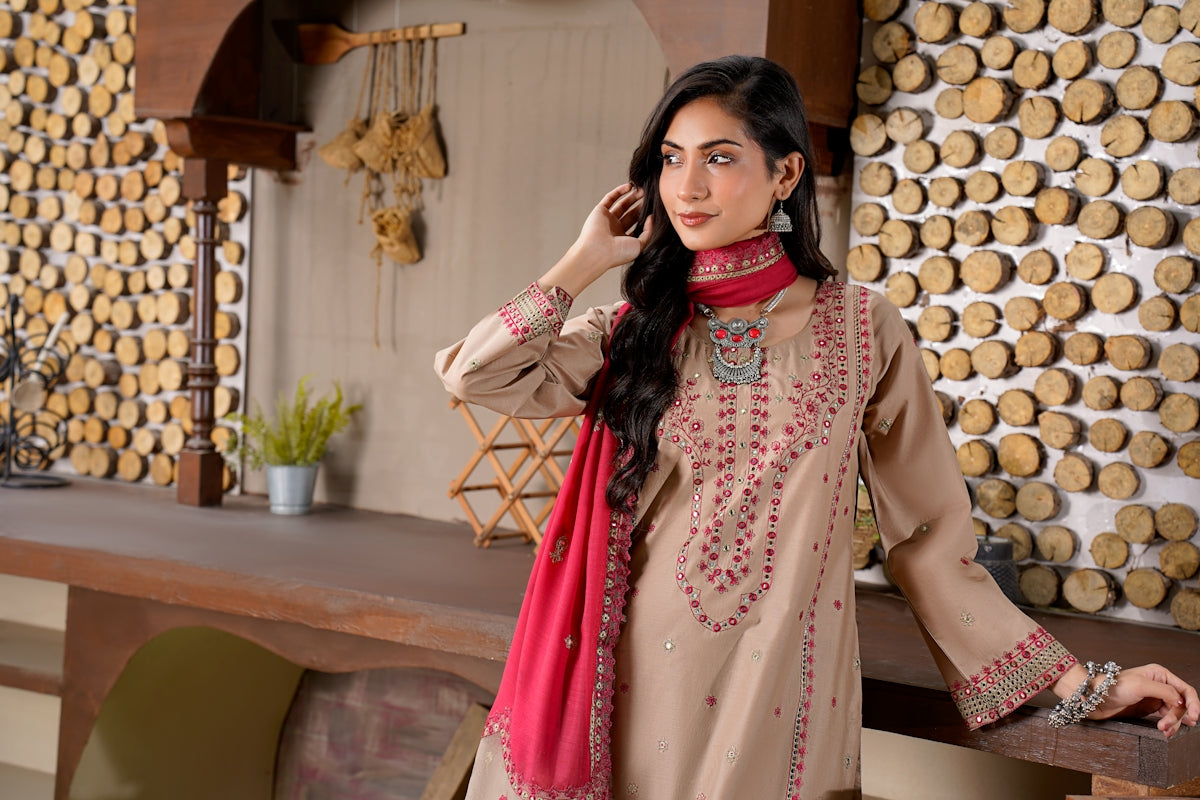 A woman in a beige dress with red scarf.